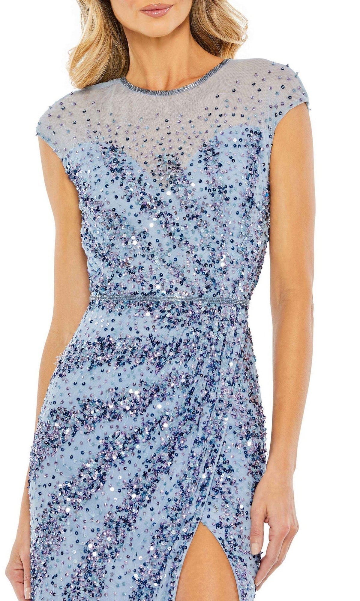 A woman wearing the Mac Duggal 5619 Sleeveless Beaded Long Formal Dress, featuring a light blue color, high slit, and sheer neckline.
